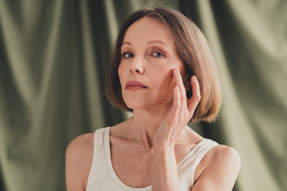 Unretouched photo of mature woman touching her face